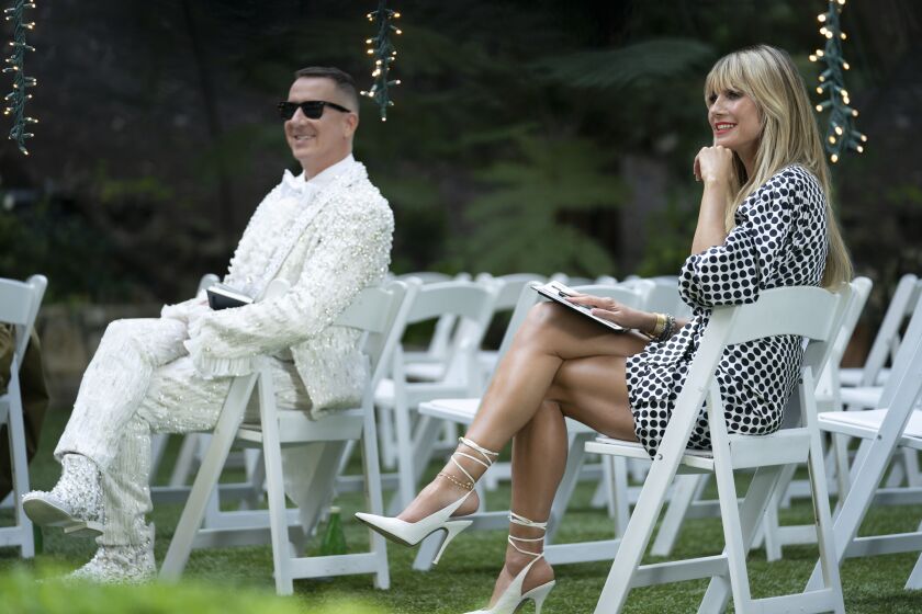 A man and a woman at an outdoor venue filled with white chairs