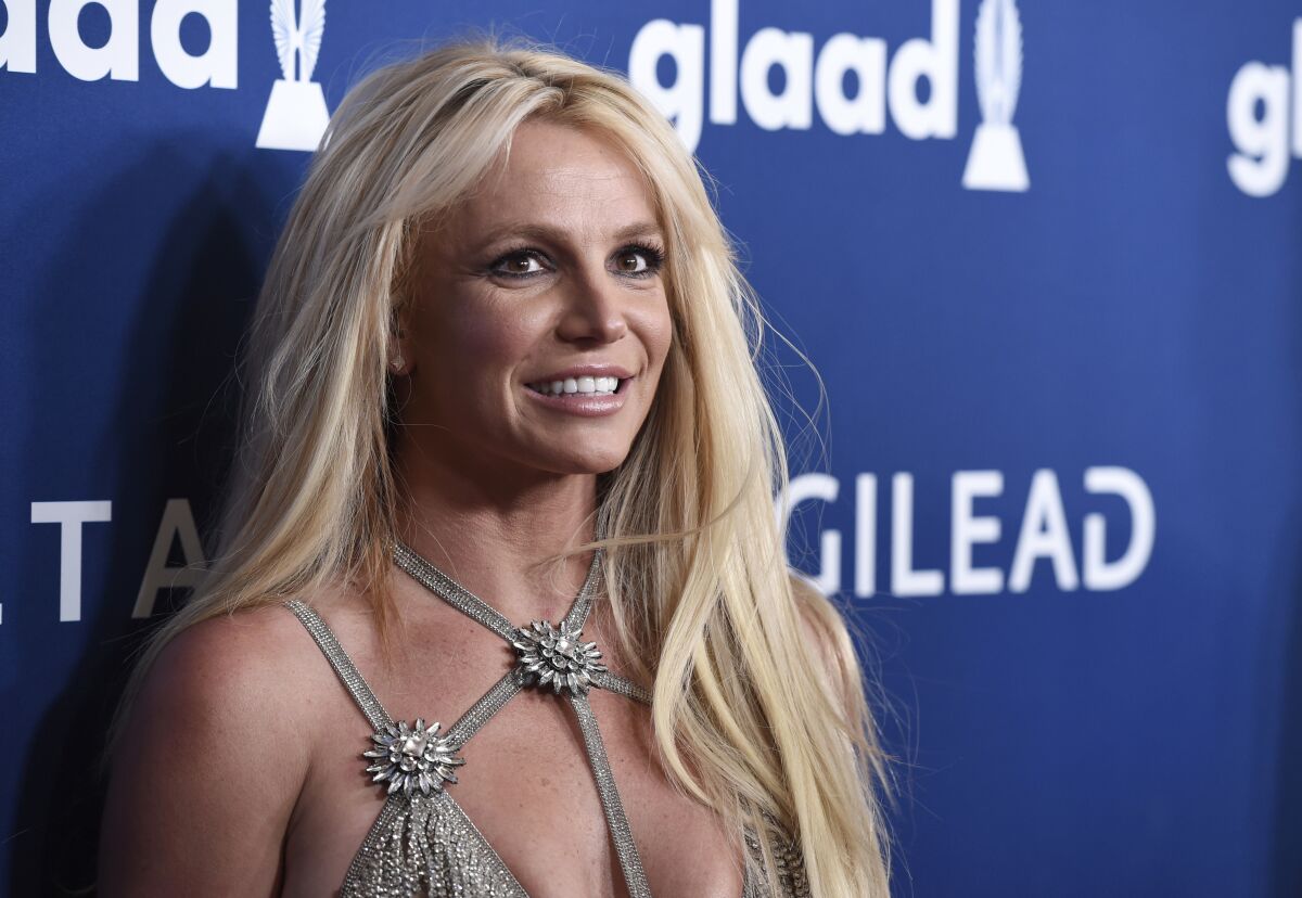 Britney Spears pictured from chest up, arriving at annual GLAAD Media Awards in 2018, smiling at the cameras 