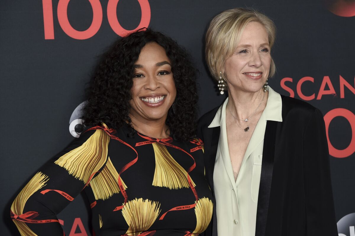 Two women pose together at a red carpet event.