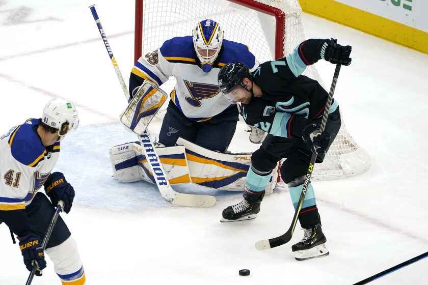 Seattle Kraken's Joonas Donskoi, right, tries to get a shot off as St. Louis Blues goaltender Ville Husso watches during the first period of an NHL hockey game Friday, Jan. 21, 2022, in Seattle. (AP Photo/Elaine Thompson)