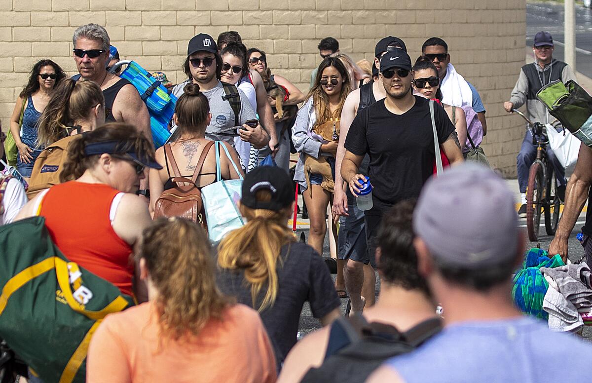 In late April in Huntington Beach, a crowd heads to the beach without social distancing or masks.