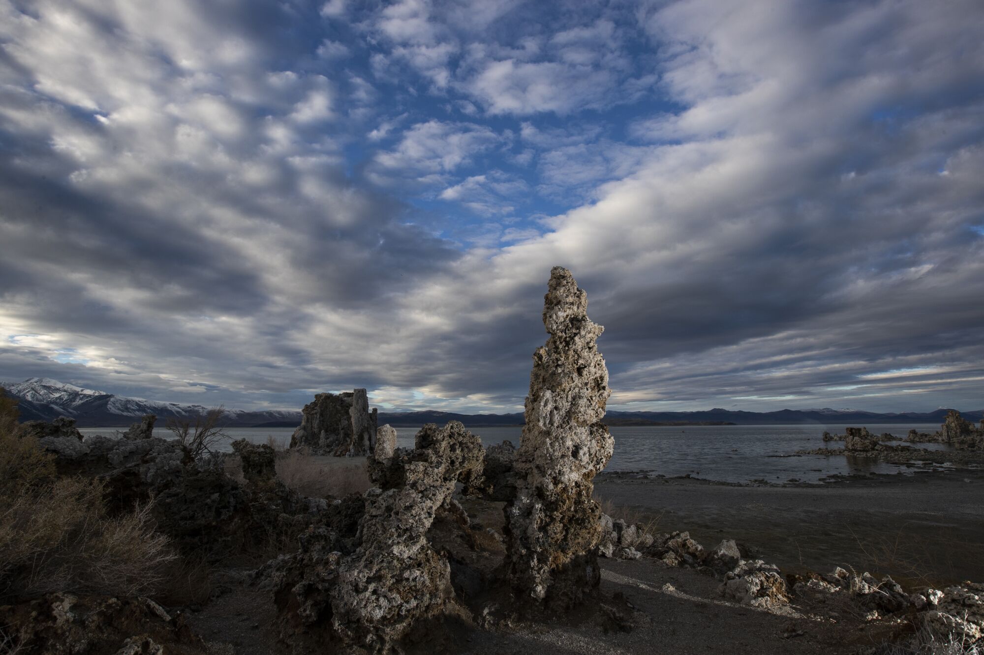 Rock-like formations in front of a lake.