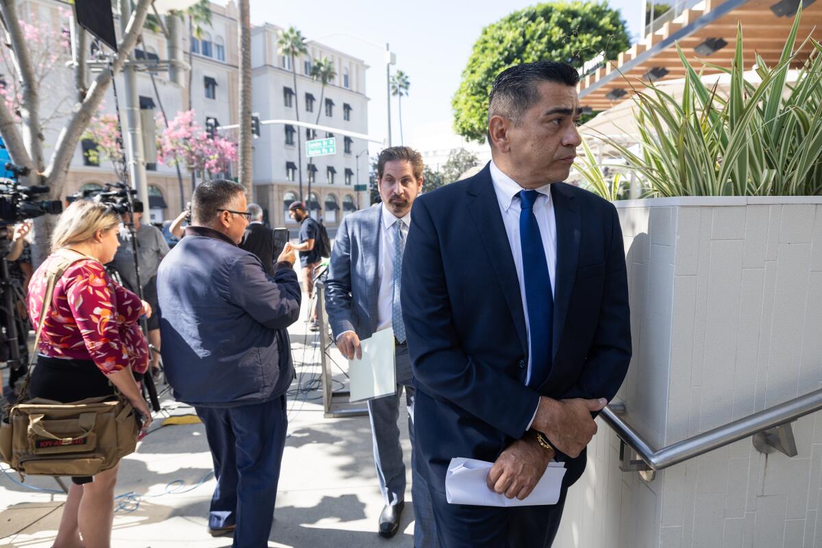 Al Labrada stands outside wearing a suit