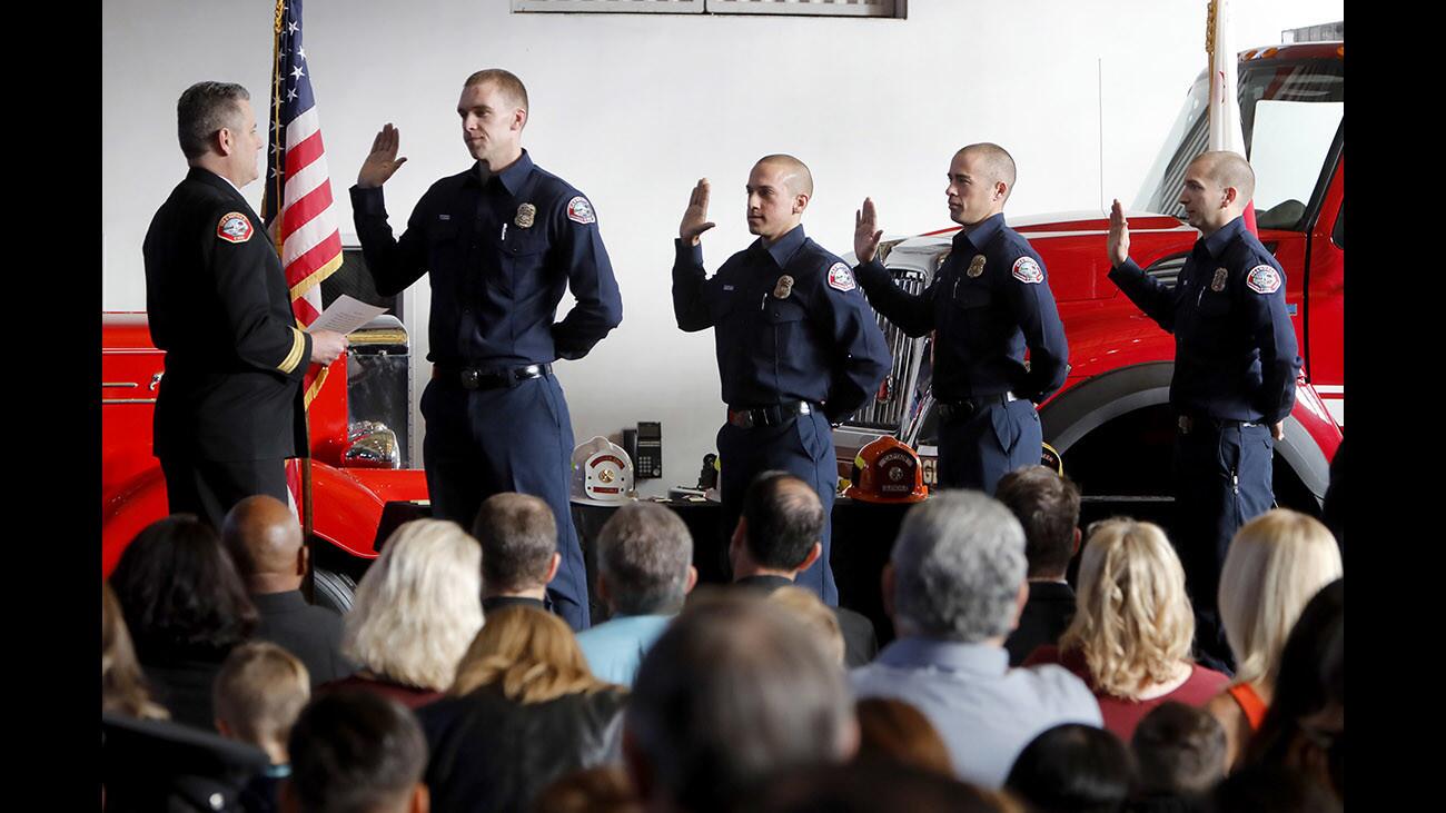 From left, Glendale Fire Dept. Chief Greg Fish swears in new firefighters Garrett Todd, Erik Quintana, Dylan Butcher and Frank Avent during promotion ceremony at station 21 firehouse in Glendale on Thursday, Jan. 18, 2018.