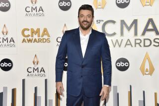 Chris Young arrives at the 57th Annual CMA Awards in a blue suit