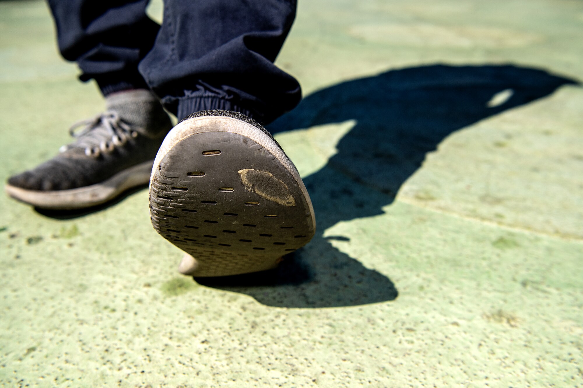 A foot lifts up to show the sole of a shoe.