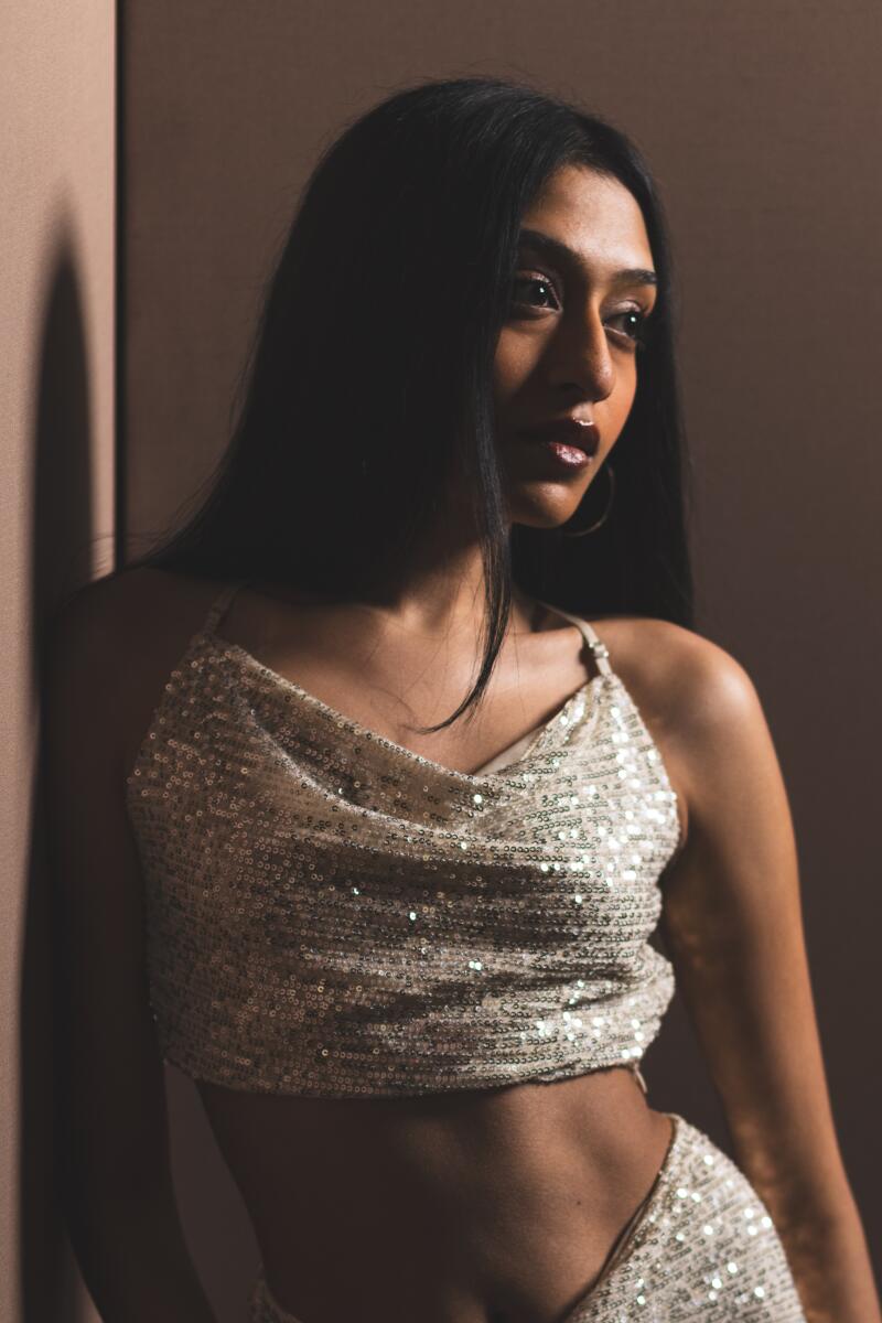 Sri Ramesh wears a sparkly white camisole top and bare midriff.