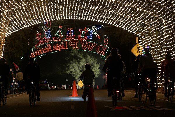 Bicyclists tour through the Griffith Park's Tunnel of Lights in a preview of the Los Angeles Department of Water and Power's 14th annual Holiday Light Festival, which will be open to pedestrians Friday through Dec. 17. Drivers will be allowed through the route Dec. 18 to 30.