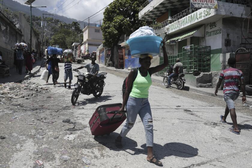 FILE - Residents flee their homes to escape clashes between armed gangs in the Carrefour-Feuilles district of Port-au-Prince, Haiti, Aug. 25, 2023. The United Nations Security Council approved on Oct. 2 the deployment of an international armed force to Haiti. (AP Photo/Odelyn Joseph, File)