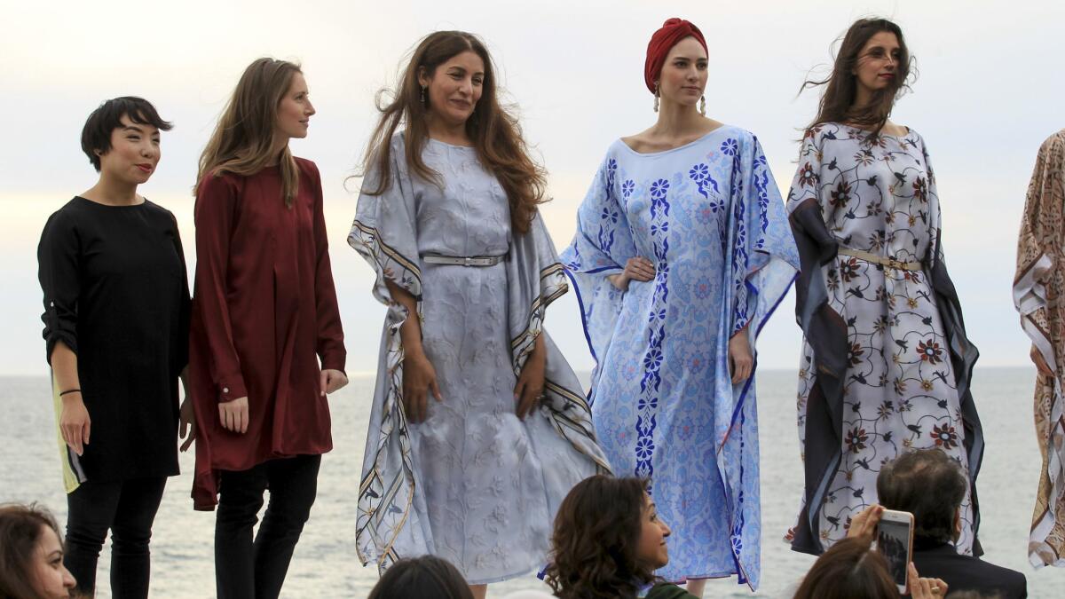 Sarah Ansari, third from left, stands with models at the conclusion of an Artizara fashion show Sunday in Encinitas.