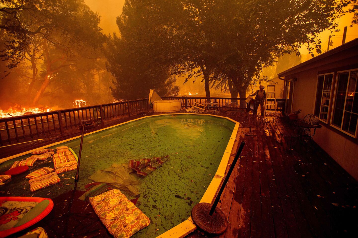 A firefighter gathers water from a pool while battling the Ranch Fire near Clearlake Oaks on Saturday.