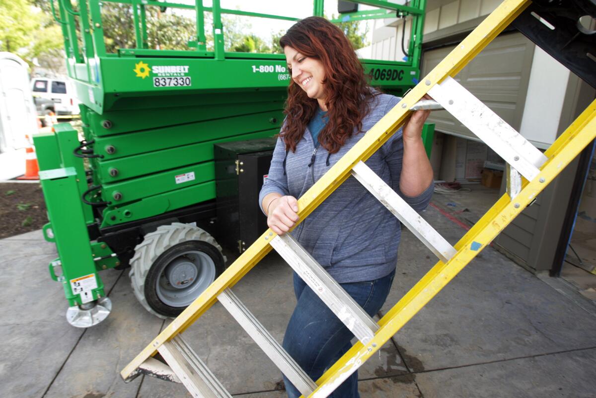Lindsey Lesher, San Gabriel Valley Habitat for Humanity construction supervisor, carries a ladder out of a garage at Chestnut Homes, the newest project near completion by Habitat for Humanity, on Friday, March 11, 2016.