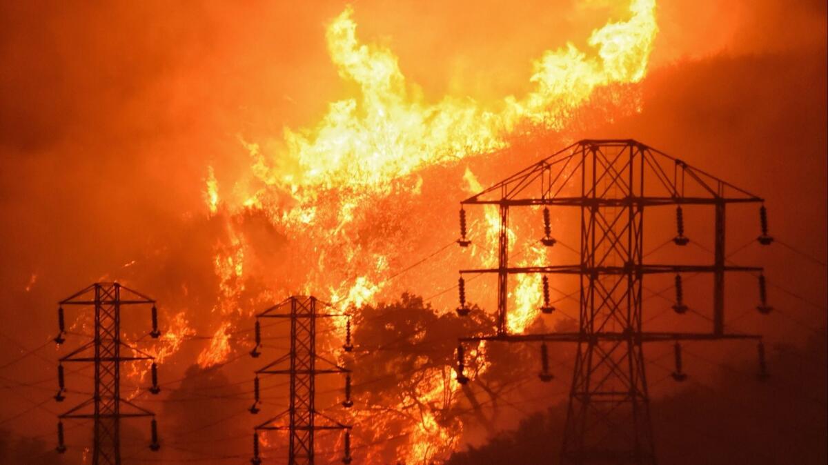 Flames burn near power lines in Montecito, Calif., in 2017.