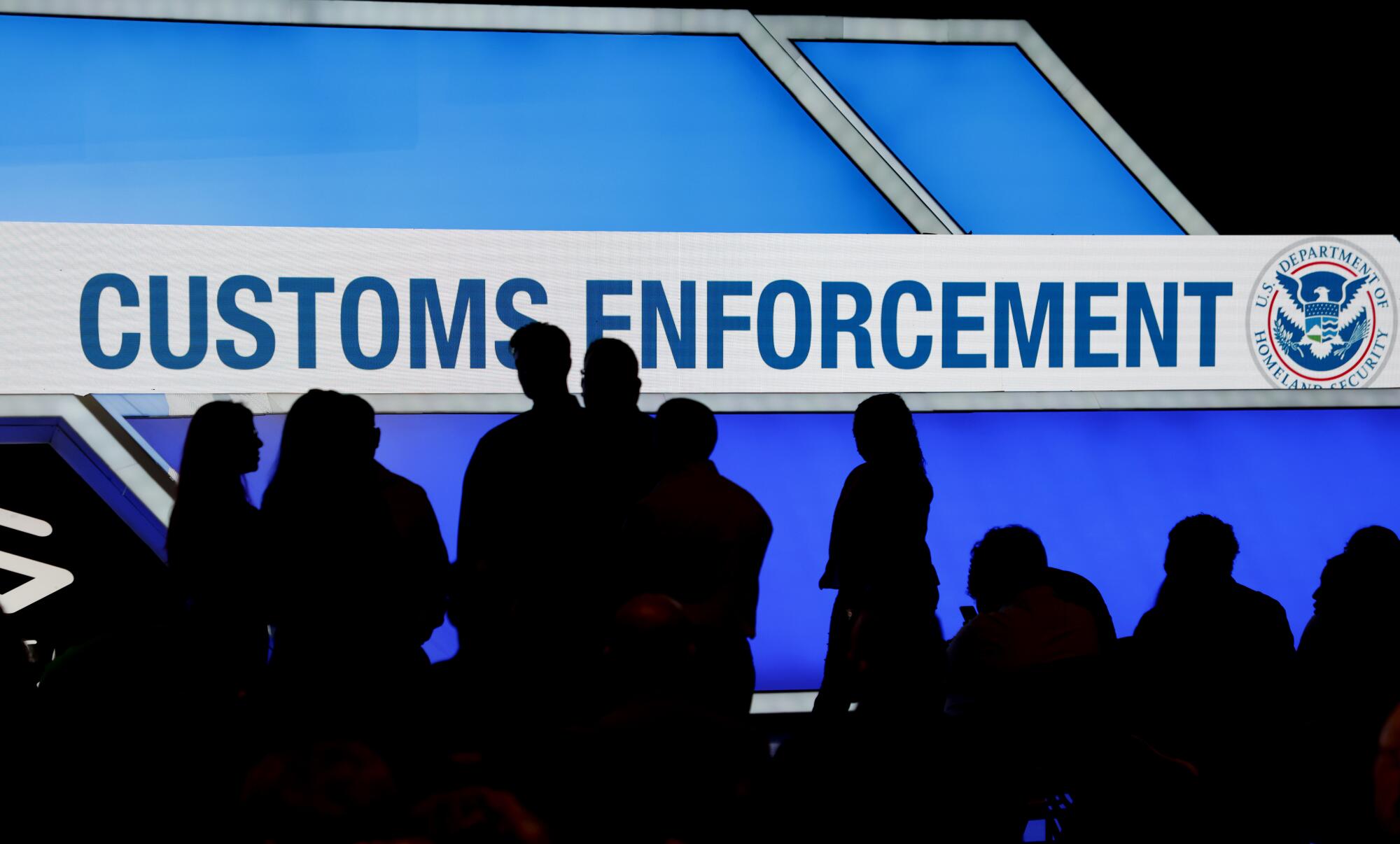 People wait for information as Immigration and Customs Enforcement holds a hiring event.