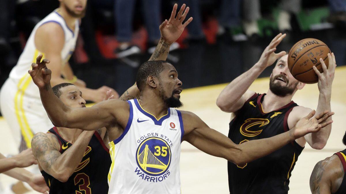 Golden State Warriors' Kevin Durant (35) and Cleveland Cavaliers' Kevin Love, right, vie for a loose ball during the first half of Game 3 of the NBA Finals.