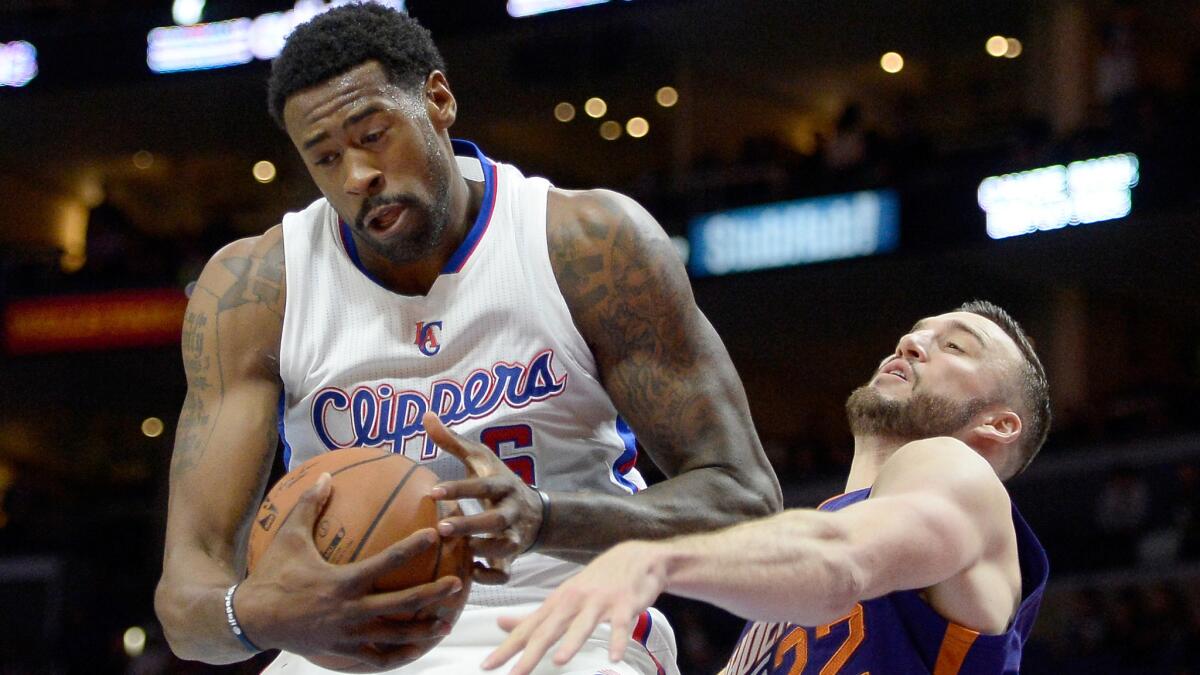 Clippers center DeAndre Jordan, left, pulls down a rebound in front of Phoenix Suns center Miles Plumlee during the Clippers' 120-107 victory Saturday at Staples Center.