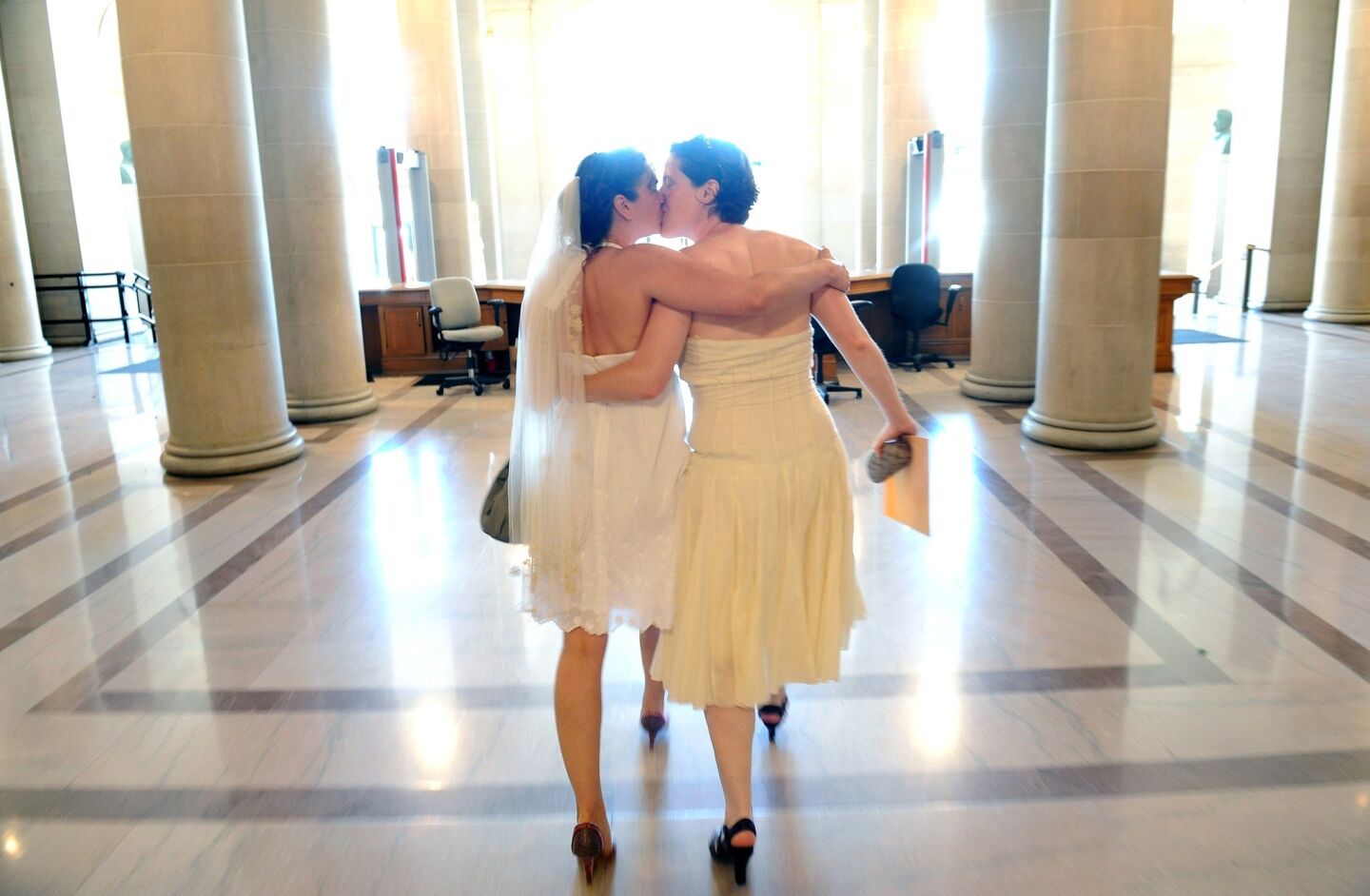 Cynthia Wides, left, and and Elizabeth Carey of Oakland walk out of City Hall a married couple Saturday in San Francisco.