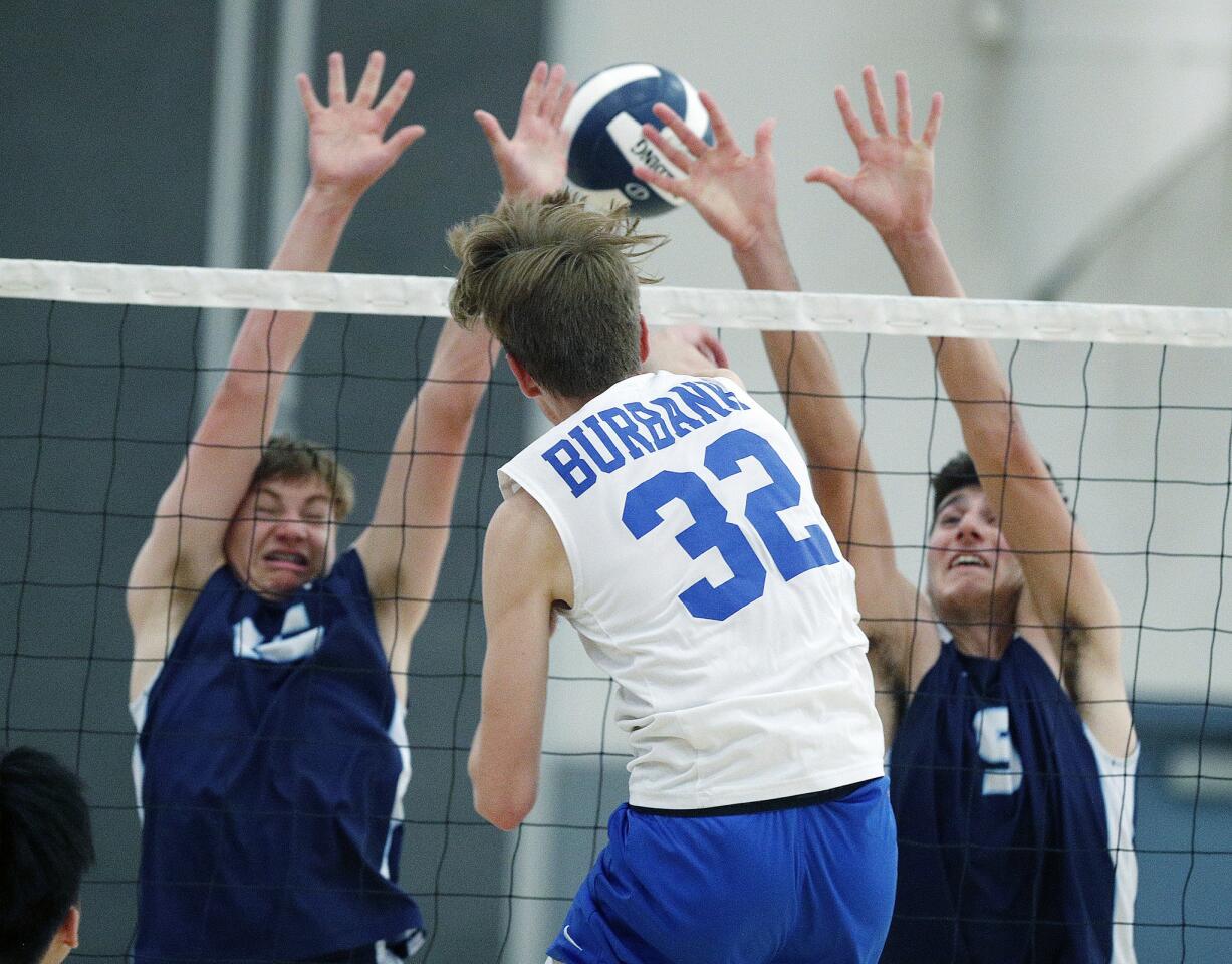 Burbank's Luca Bily hits a kill against Crescenta Valley's Joe Pincini and Garo Barsemian in a Pacific League boys' volleyball match at Crescenta Valley High School on Thursday, April 18, 2019. Burbank won the match 3-1.