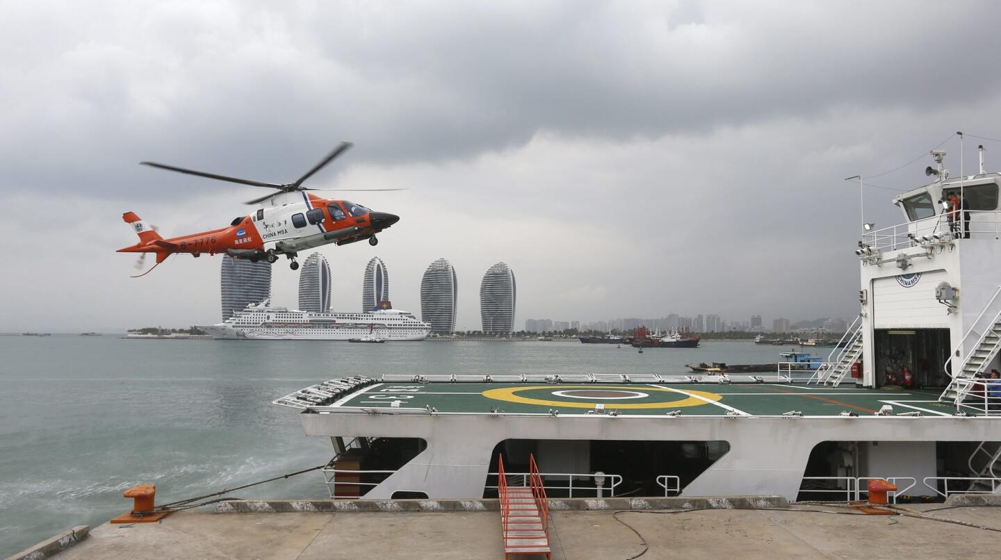 A helicopter arrives on the rescue ship Haixun-31 of the China Maritime Safety Administration at the port during a brief stop for supplies in Sanya.