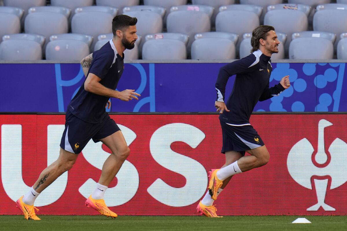 France's Antoine Griezmann and Olivier Giroud run during a training session.