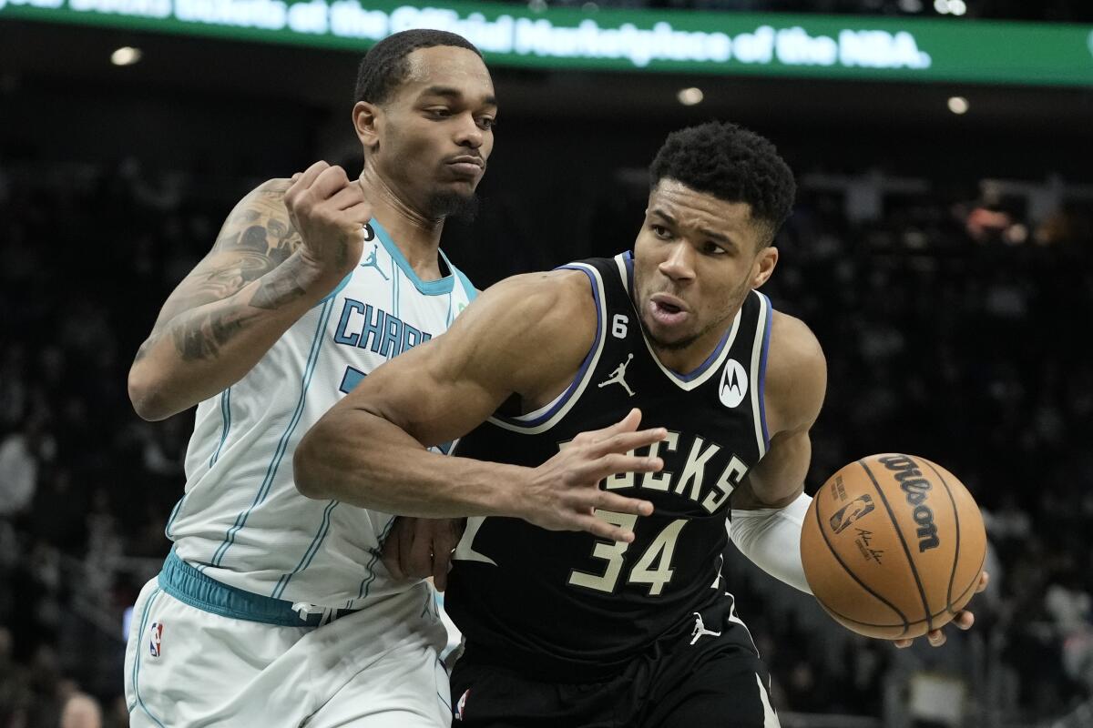 Milwaukee Bucks' Giannis Antetokounmpo drives past Charlotte Hornets' P.J. Washington during the second half of an NBA basketball game Tuesday, Jan. 31, 2023, in Milwaukee. The Bucks won 124-115. (AP Photo/Morry Gash)