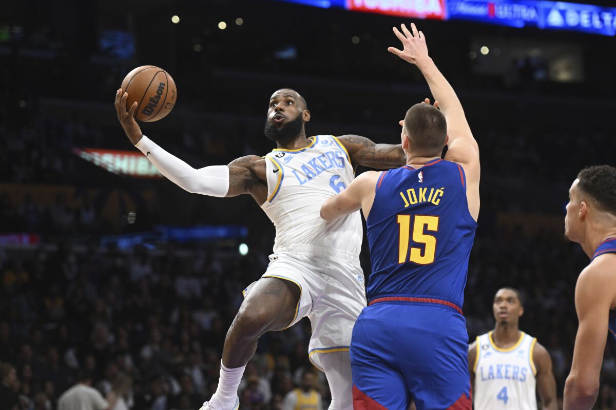 Lakers forward LeBron James drives to the basket past Denver Nuggets center Nikola Jokic during the first half.