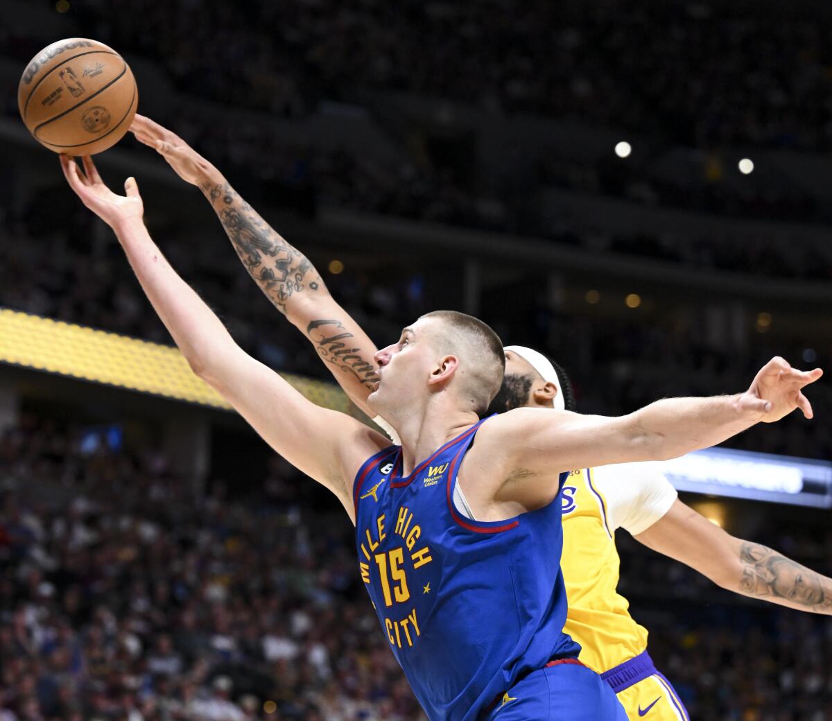 Nuggets center Nikola Jokic, front, shoots while pressured by Lakers forward Anthony Davis during Game 1.
