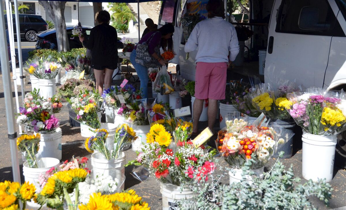 Customers flock to David Franco's flower stand at the Corona del Mar farmers market.