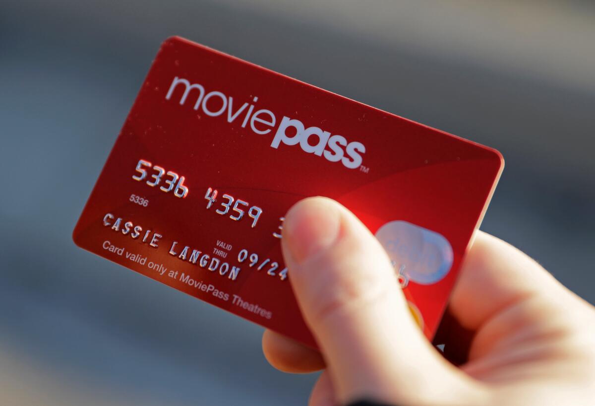 A hand holding a red MoviePass credit card 