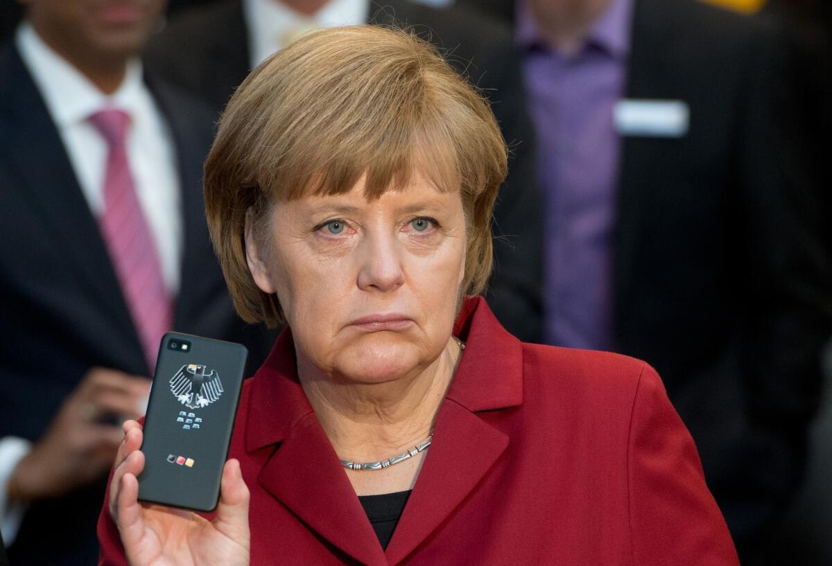 German Chancellor Angela Merkel presents a tap-proof mobile BlackBerry phone at the CeBIT computer expo in Hanover, Germany.