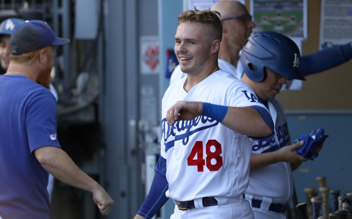 Dodgers second baseman Gavin Lux smiles in the dugout after scoring a run against the Colorado Rockies in his major league debut on Monday.