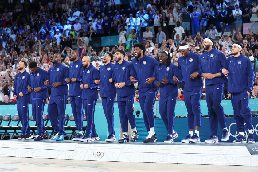 American basketball players celebrate their win against France in the gold-medal match Saturday in Paris.