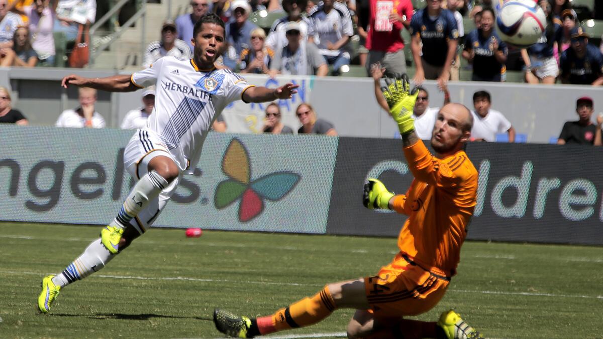 Galaxy forward Giovani Dos Santos scores against Sounders goalkeeper Stefan Frei in the 64th minute of his MLS debut on Aug. 9 at StubHub Center.