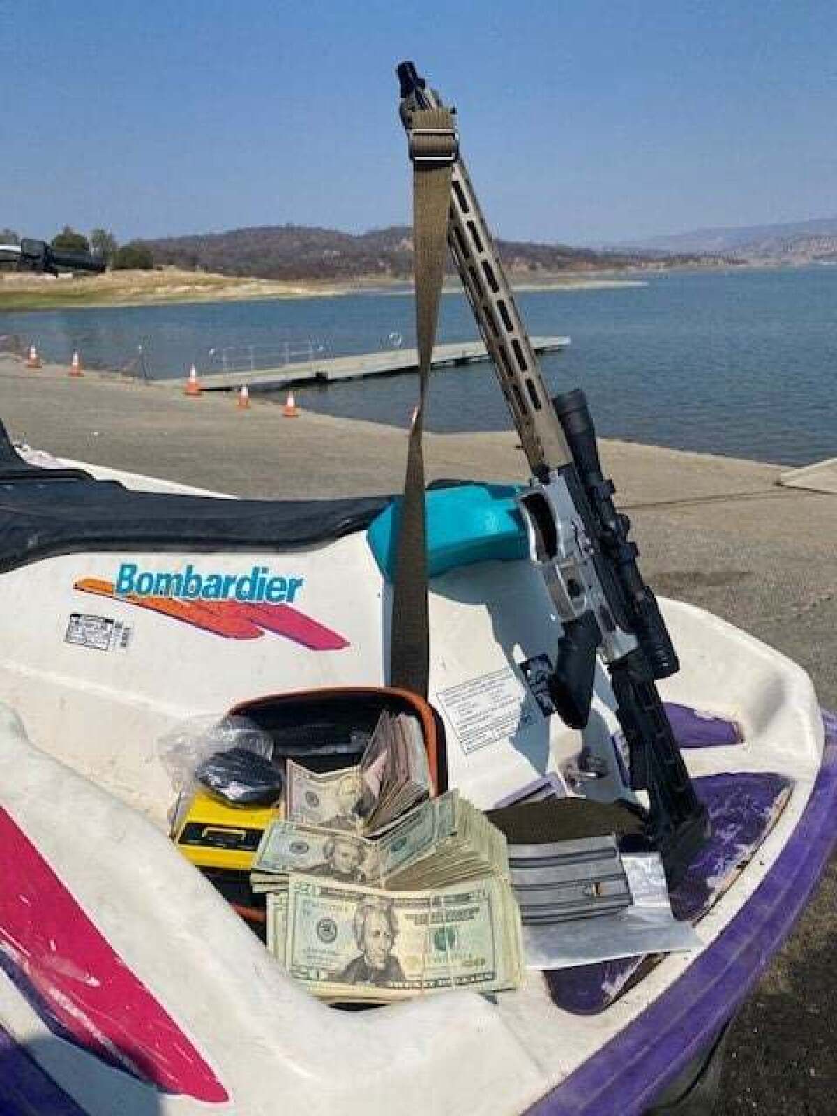 An AR-15 rifle and cash on a water scooter