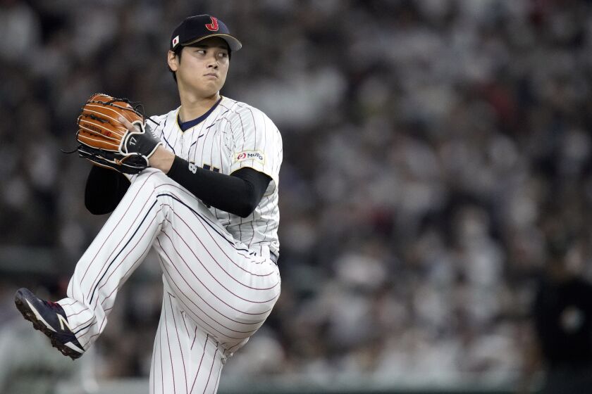 Japan pitcher Shohei Ohtani winds up to throw against Italy 