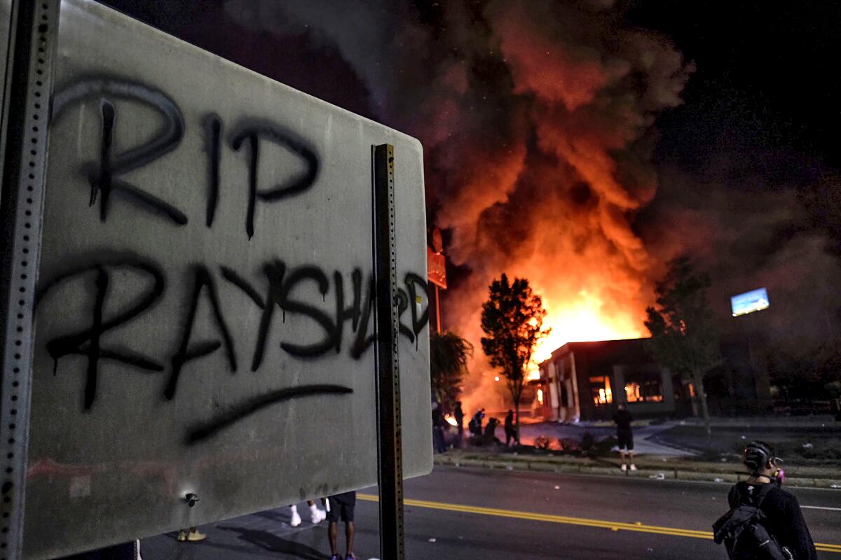 A Wendy's restaurant, background, in Atlanta after it was set on fire.