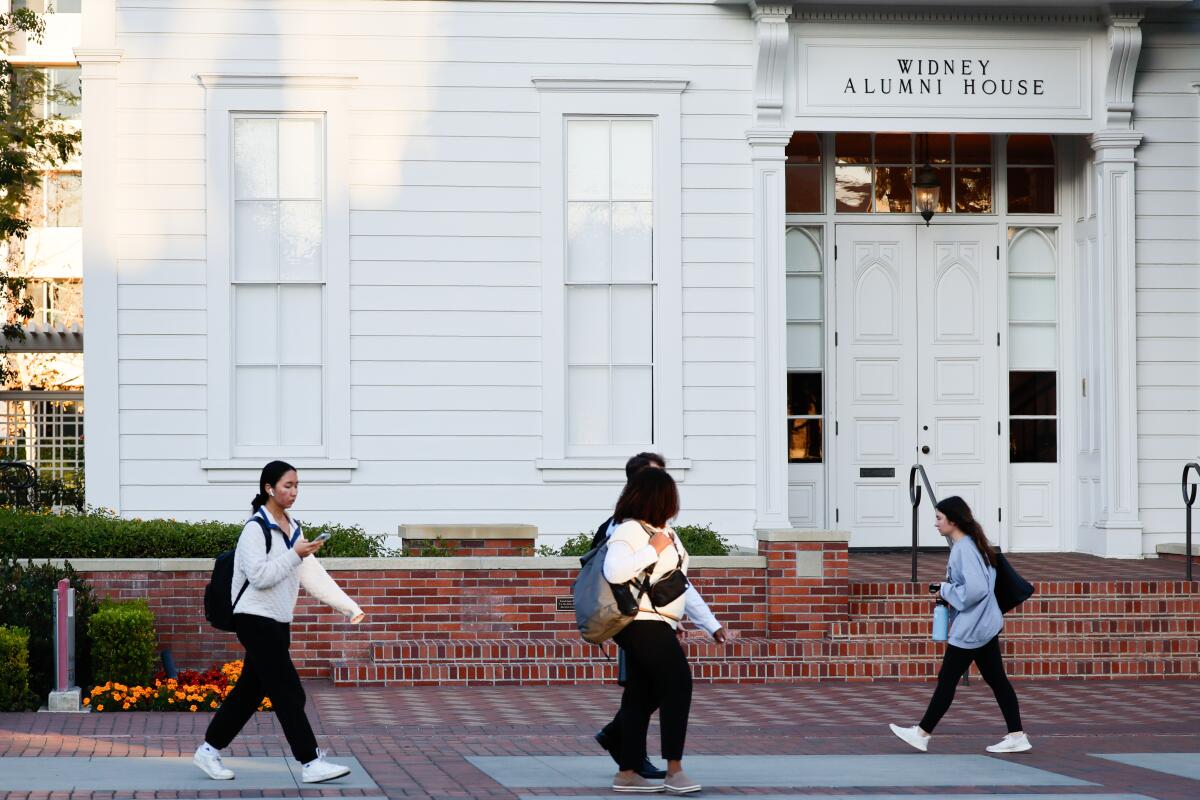 Students walk past a building at USC.