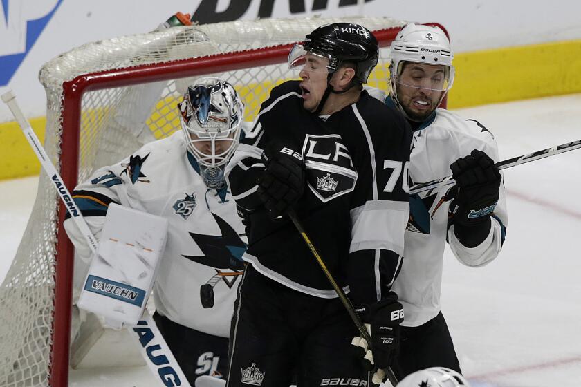 Kings forward Tanner Pearson deflects the puck in front of Sharks goalie Martin Jones and defenseman Brenden Dillon during third period of Game 2 of the teams' playoff series.