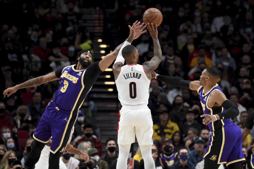 Portland's Damian Lillard hits a three-pointer versus the Lakers' Anthony Davis, left, and Russell Westbrook on Nov. 6, 2021.