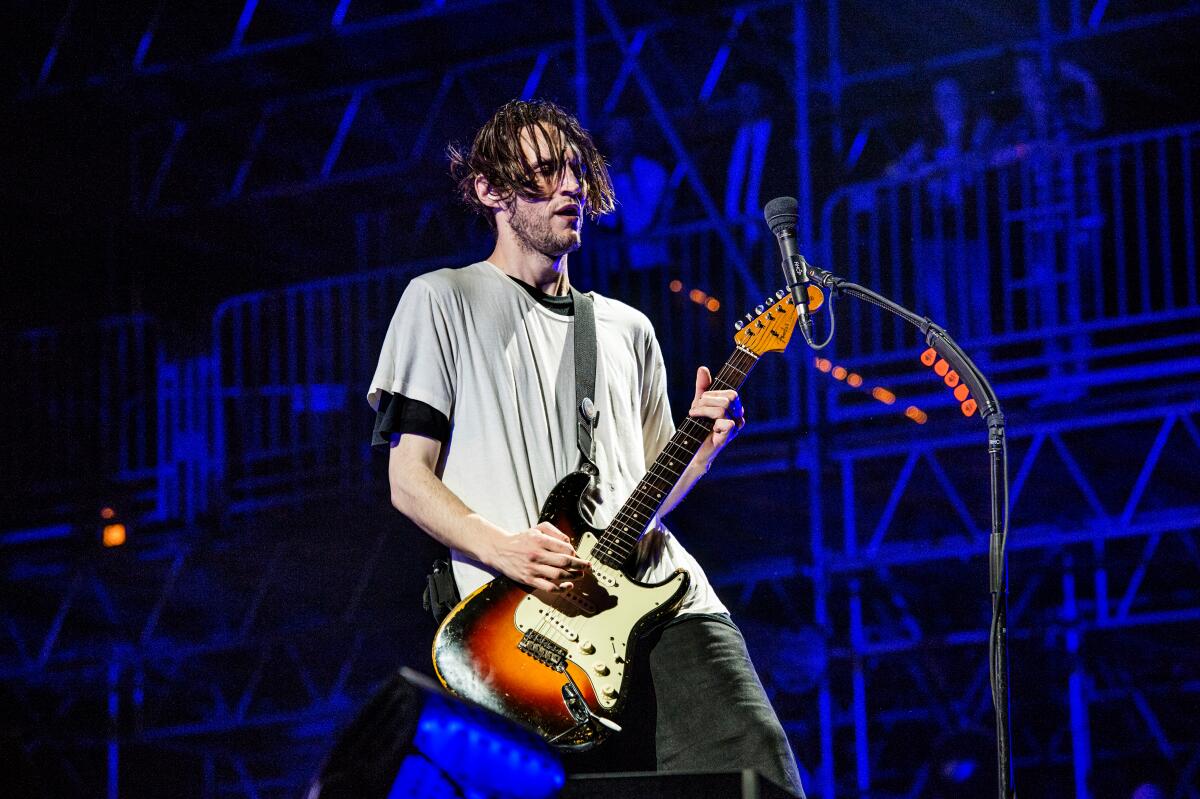 Josh Klinghoffer plays guitar on stage.