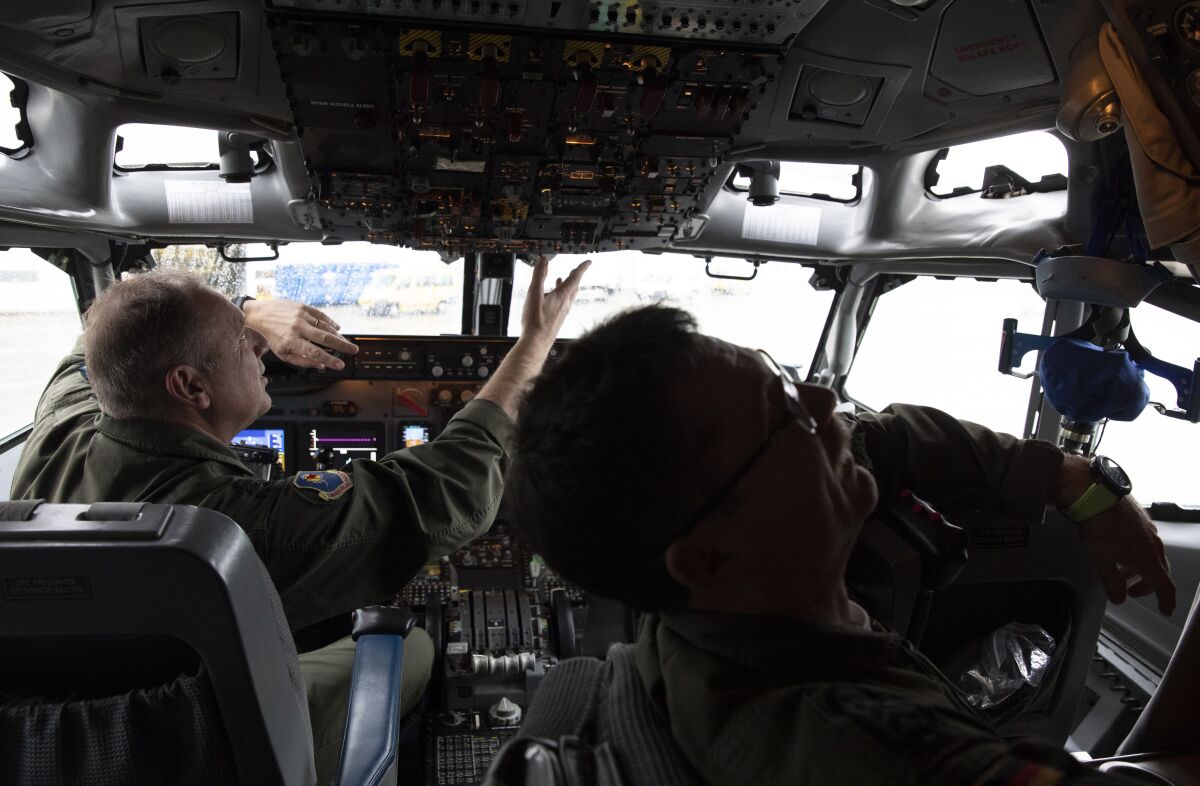 FILE - Pilots work in the cockpit of an AWACS plane at Melsbroek military airport in Melsbroek, Belgium, Wednesday, Nov. 27, 2019. As Russia’s military buildup near Ukraine accelerated early this year, military planners at NATO began preparing to dispatch scores of fighter jets and surveillance aircraft into the skies near Russia and Ukraine. It was a warning to Moscow not to make the mistake of targeting any member country. (AP Photo/Virginia Mayo, File)