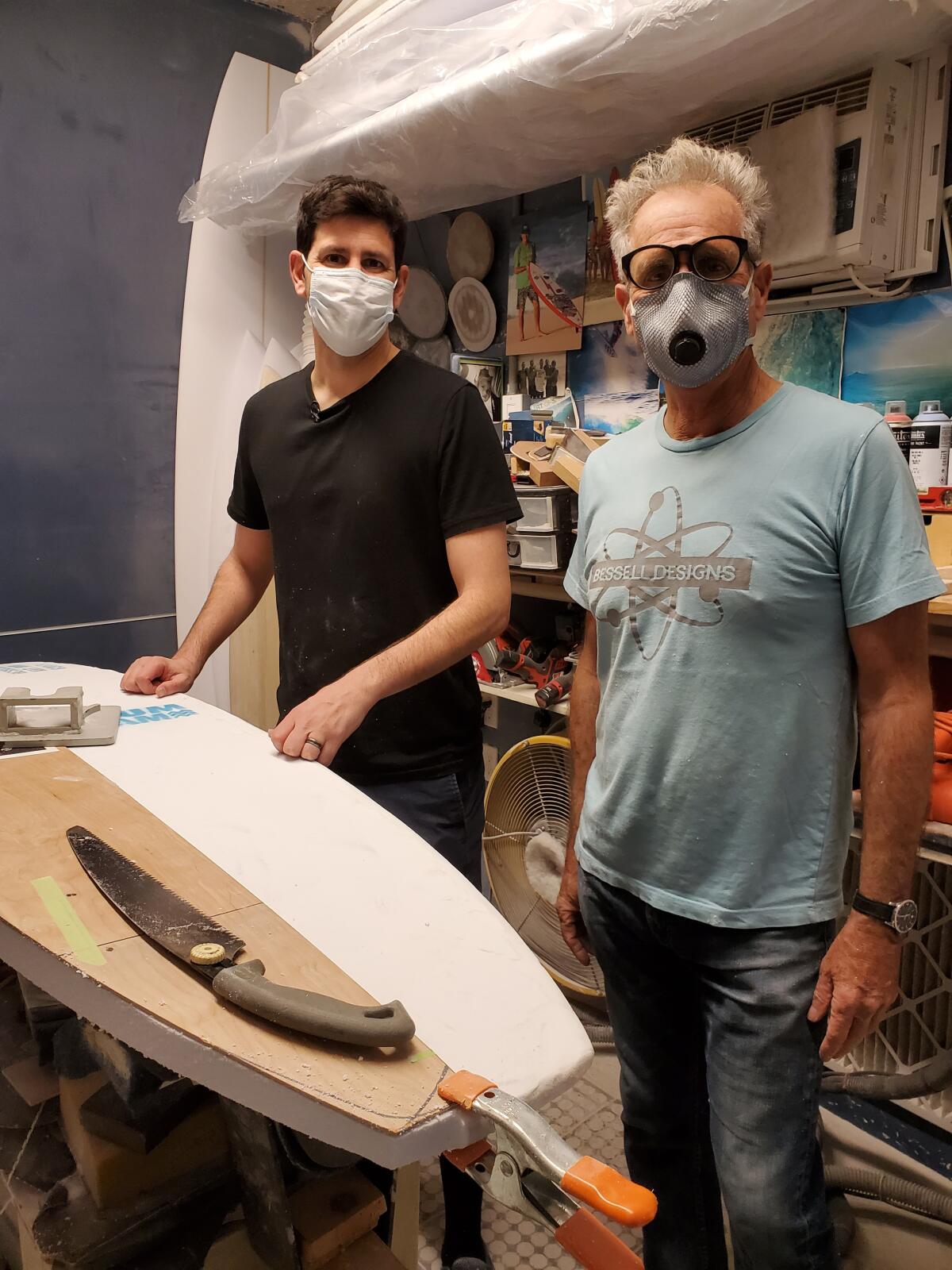 Daniel Seddiqui and La Jolla surfboard maker Tim Bessell work on a new board Jan. 27.