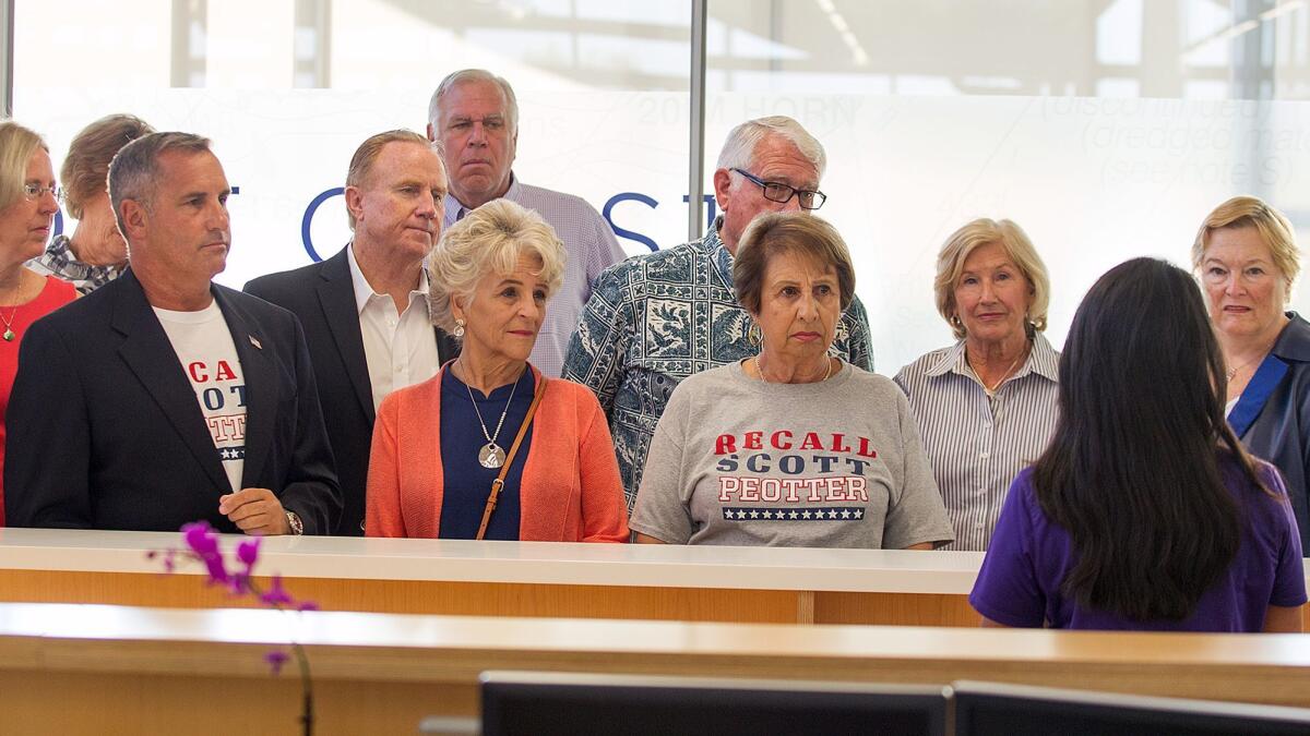 A group of people seeking the recall of Newport Beach City Councilman Scott Peotter listen Oct. 27 as City Clerk Leilani Brown explains the process for counting recall petition signatures.