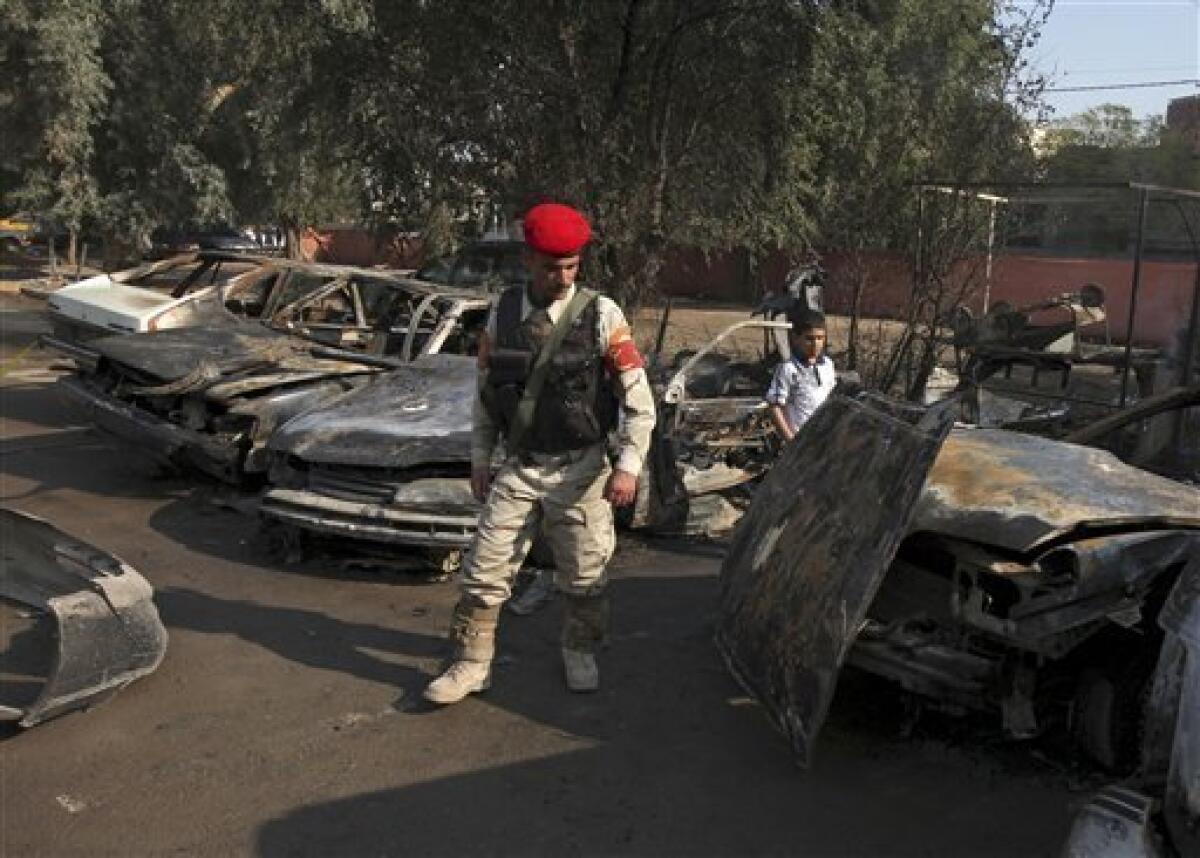 An Iraqi soldier inspects the site of a car bomb attack in Baghdad, Iraq, Tuesday, Dec. 15, 2009. A series of car bombs ripped through downtown Baghdad near the heavily fortified Green Zone. (AP Photo/Karim Kadim(