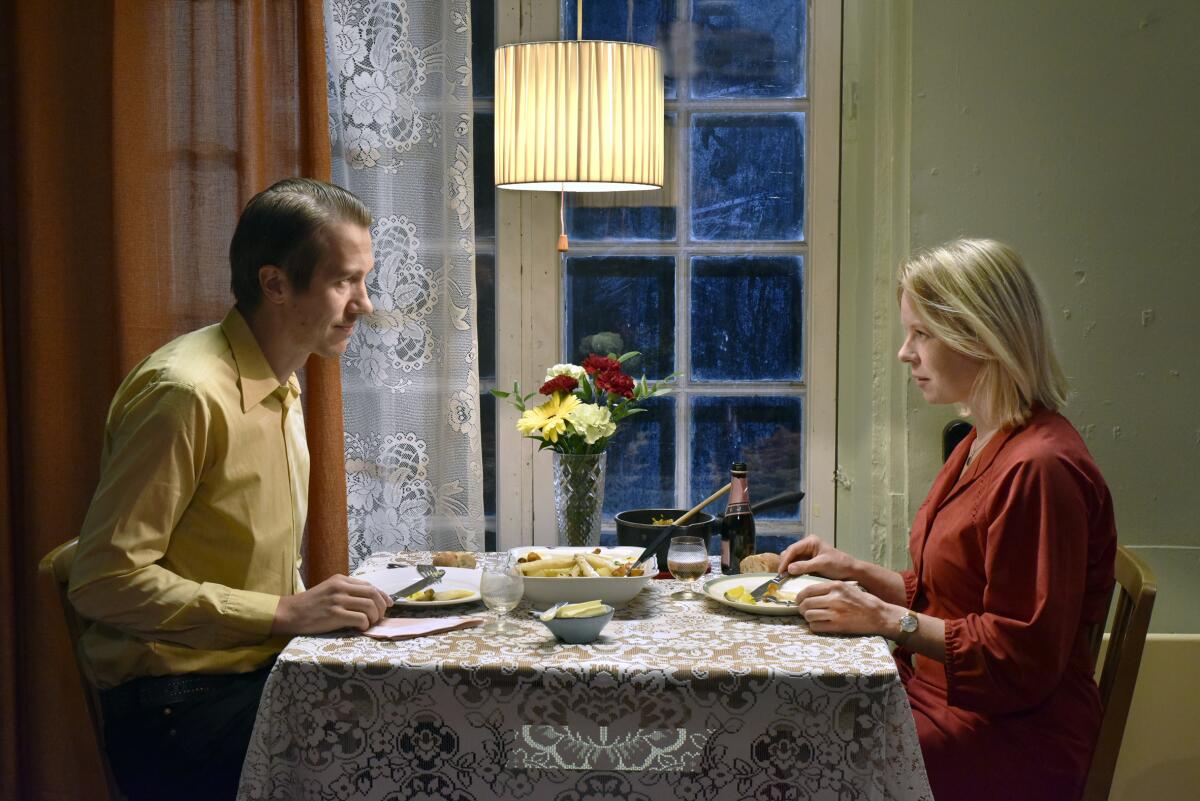 A man and a woman sit at a dinner table.
