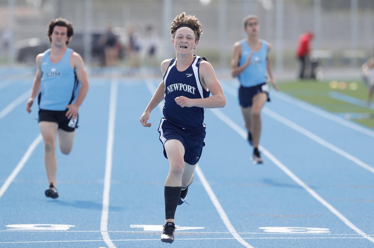 Newport Harbor's Cooper Dwight wins the boys' 100-meter run against CdM on the new track at Corona del Mar High Wednesday.