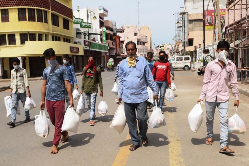 People carry grocery items distributed by Muslim volunteers for those in need during a government-imposed nationwide lockdown as a preventive measure against the COVID-19 coronavirus in Amritsar on March 26, 2020. (Photo by NARINDER NANU / AFP) (Photo by NARINDER NANU/AFP via Getty Images)
