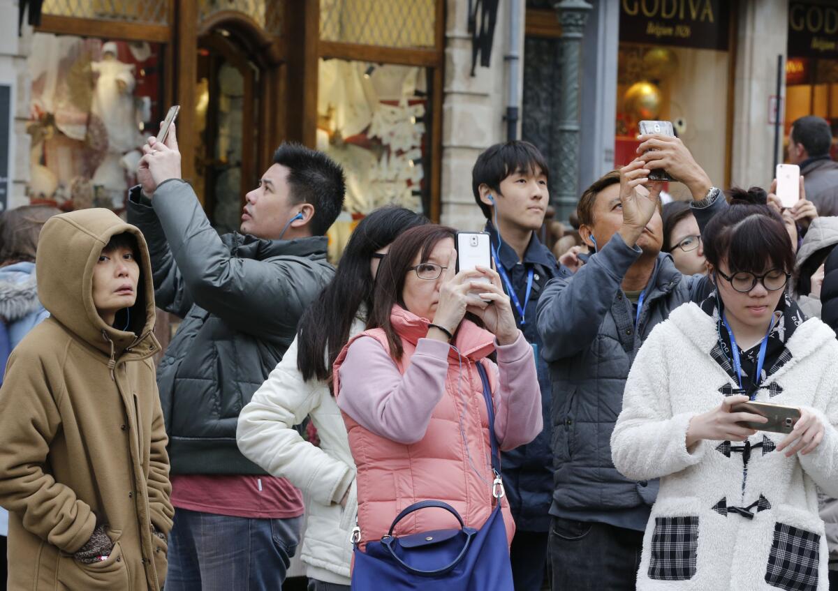 Turistas japoneses toman fotos en la Grand Place de Bruselas, Bélgica.