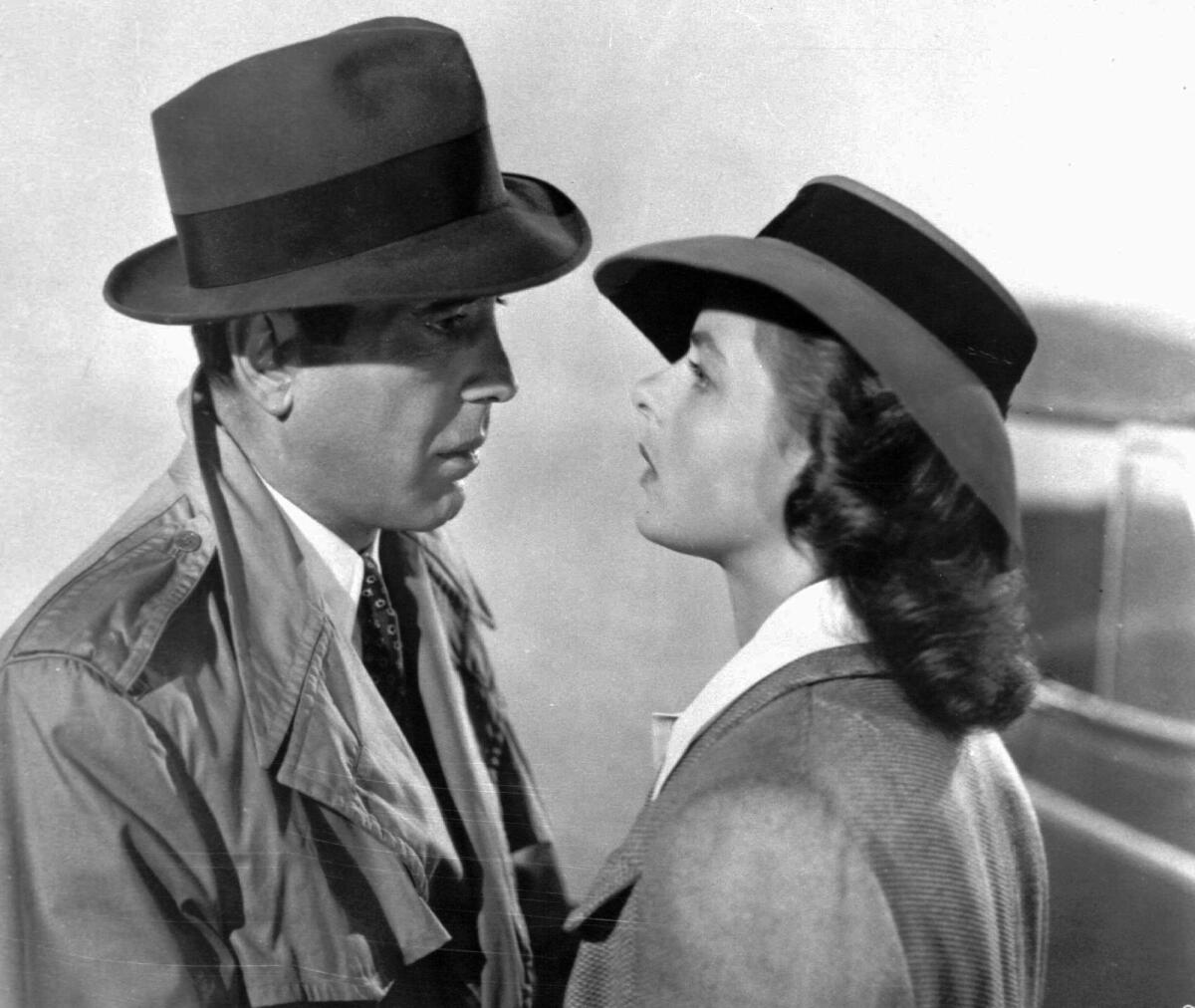 Two actors in hats flirt.