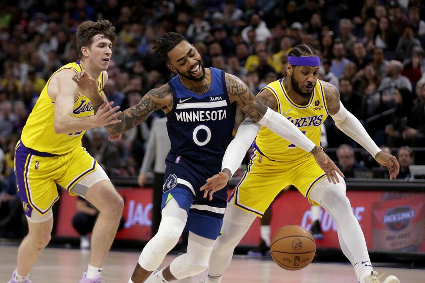 Minnesota Timberwolves guard D'Angelo Russell (0) is fouled by Los Angeles Lakers forward Carmelo Anthony (7) with Lakers guard Austin Reaves (15) also defending during the first half of an NBA basketball game Wednesday, March 16, 2022, in Minneapolis. (AP Photo/Andy Clayton-King)